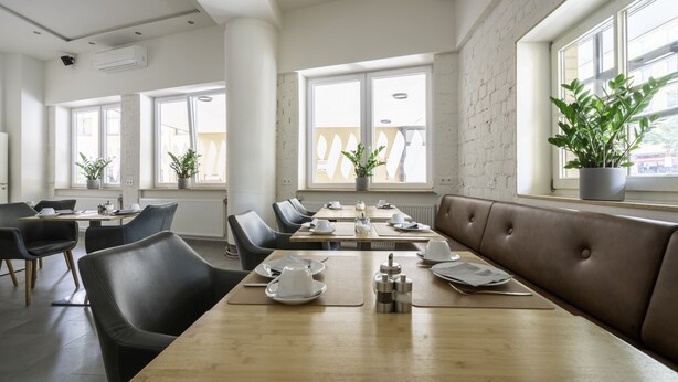 Un comedor moderno con mesas altas, asientos cómodos y amplios ventanales que dejan entrar luz natural.