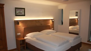 Ein Doppelbett mit Holzkopfseitenwand, einem Nachttisch und einem Spiegel.