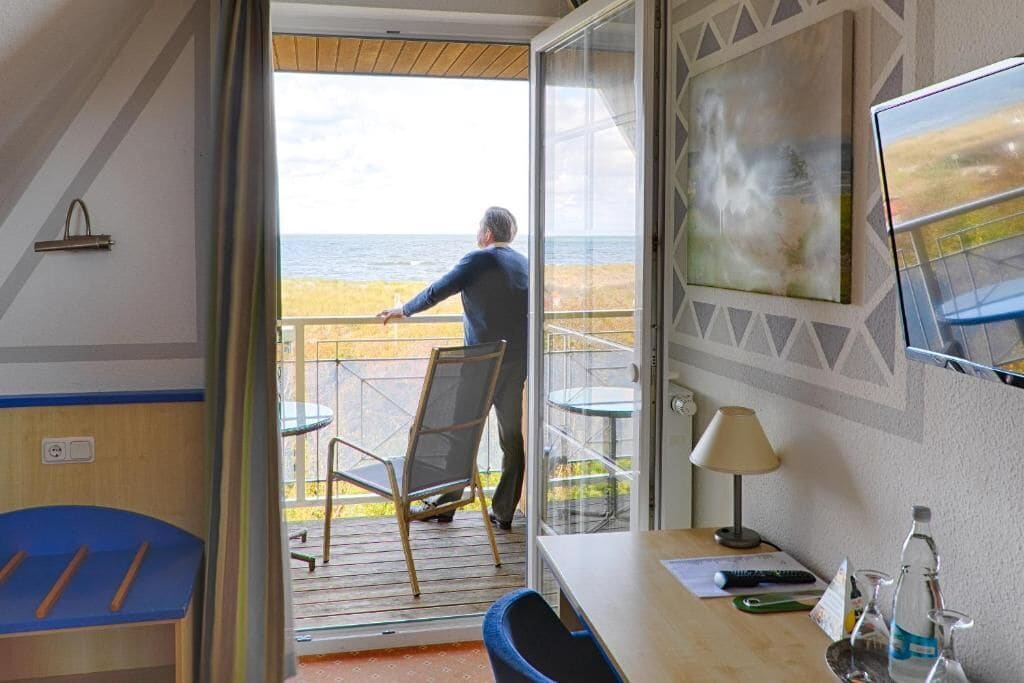 Ein Zimmer mit Meerblick, ein Schreibtisch mit Lampe und ein Stuhl.