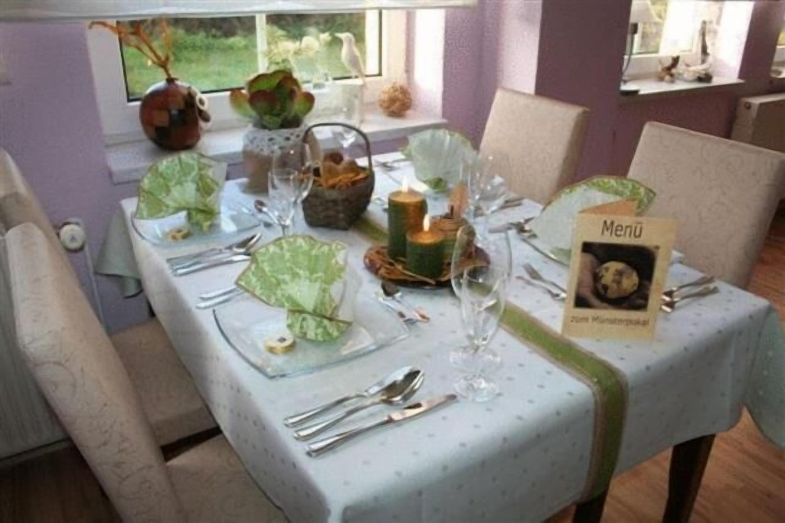 Une table à manger dressée avec de la verrerie, des couverts et un présentoir à menus.