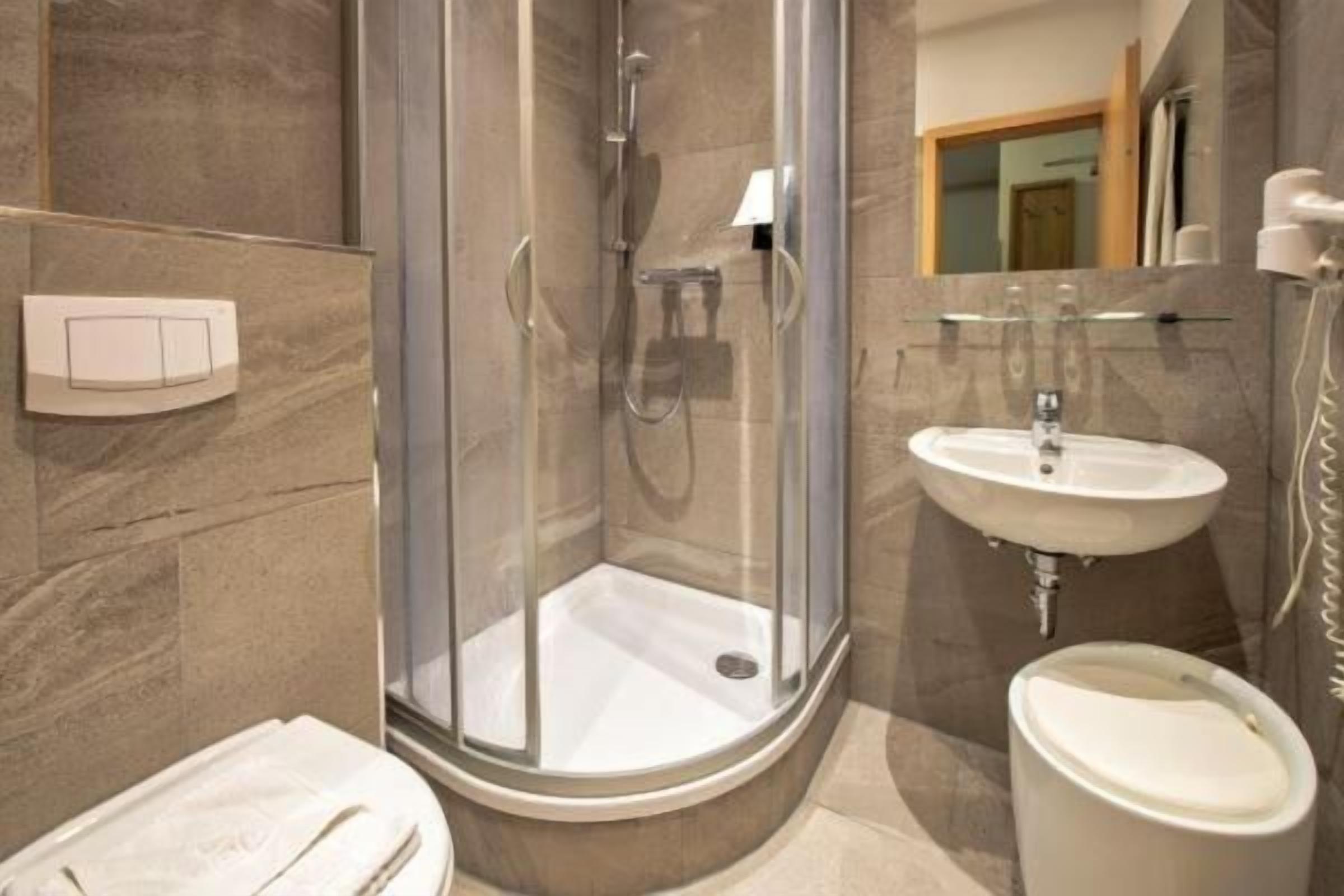 Une salle de bain moderne avec une douche à parois de verre, un lavabo et des toilettes.