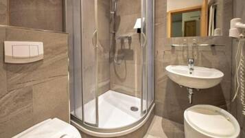 Une salle de bain moderne avec une douche à parois de verre, un lavabo et des toilettes.