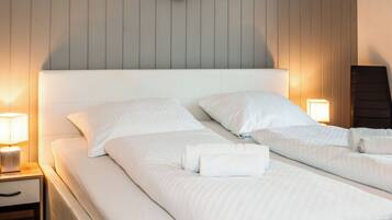 A hotel room with two beds, a wall-mounted circular decoration, and bedside lamps.