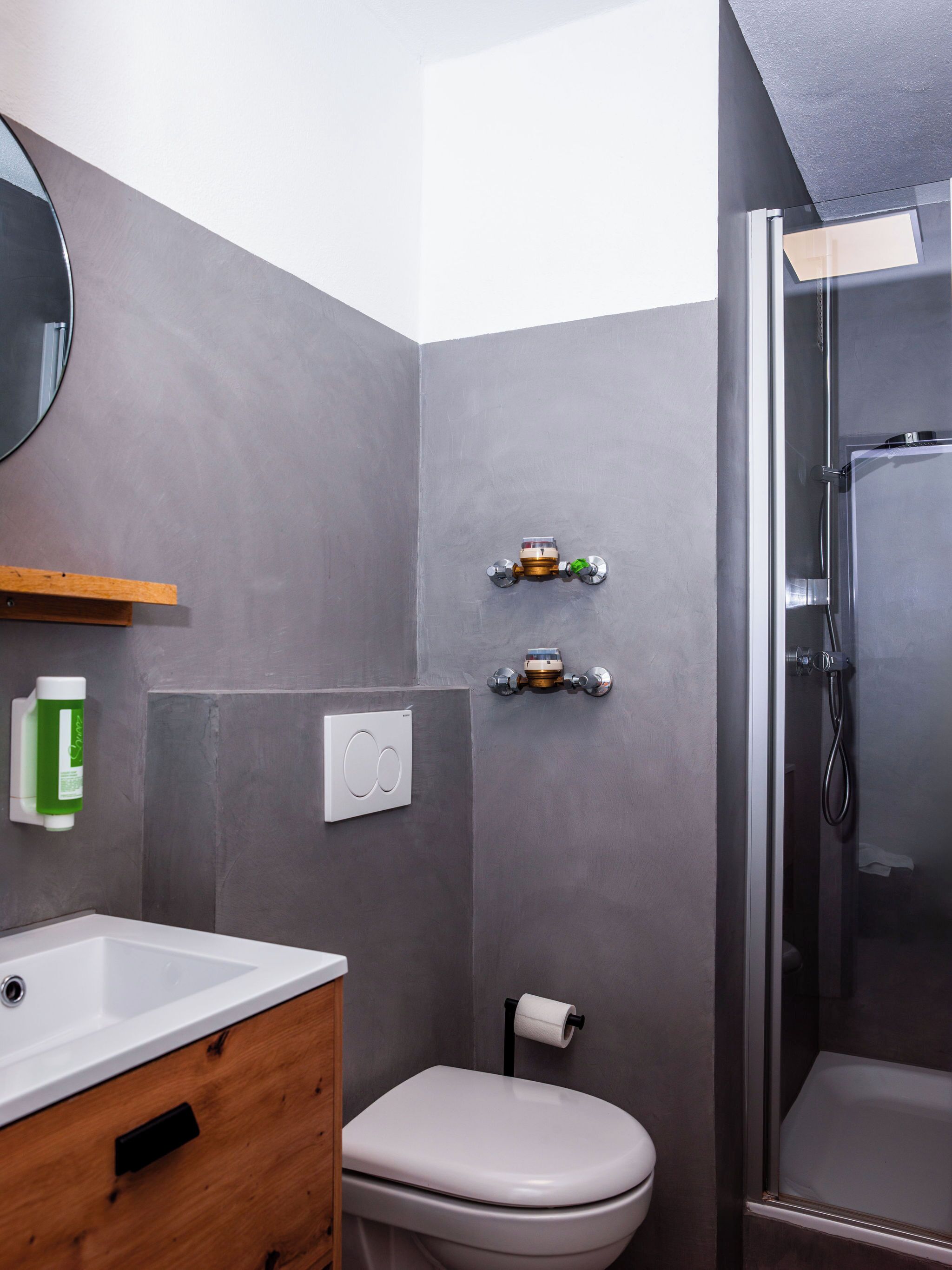 A modern bathroom with a white toilet, a sink, and a shower.