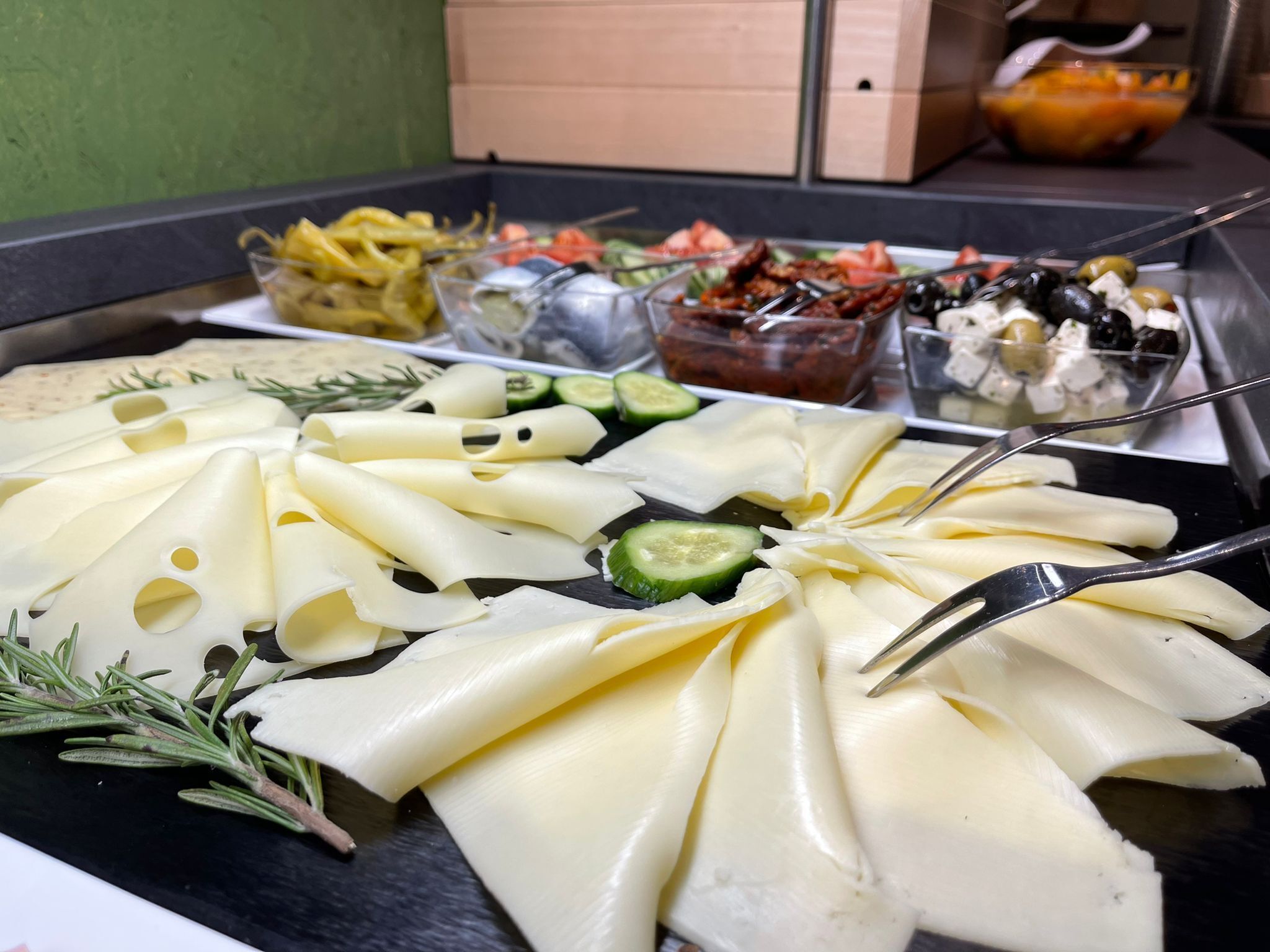 A cheese platter with various cheeses and vegetables.
