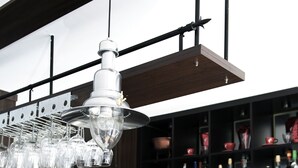 A bar area with a coffee machine, a coffee cup, and a shelf with various bottles. - Hotel Villa Stockum (Düsseldorf)