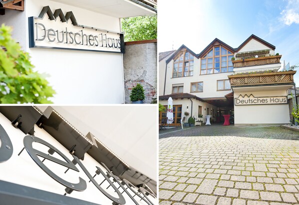 Ein Gebäude mit einem Schild, das „Deutsches Haus“ zeigt, und einem gepflasterten Innenhof.