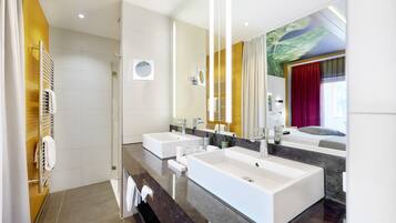 Un bagno moderno con due ampi lavabi, una doccia e un grande specchio.