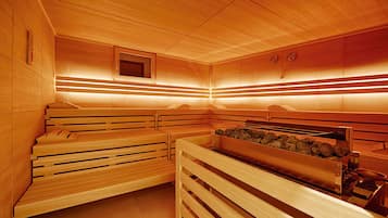 Una sauna con bancos de madera y un elemento calefactor de piedra.