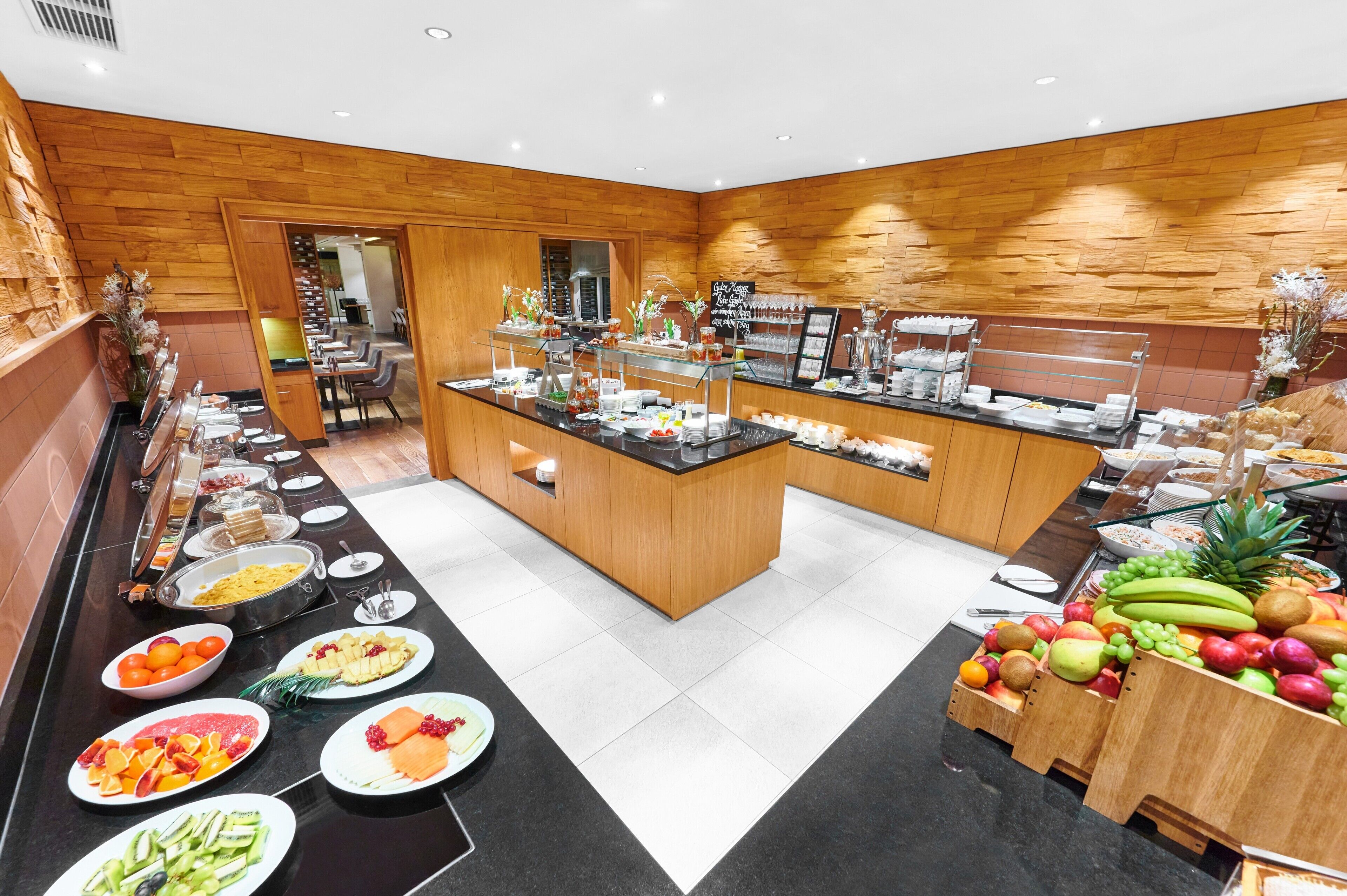 Een buffetopstelling met diverse gerechten en een fruitpresentatie.