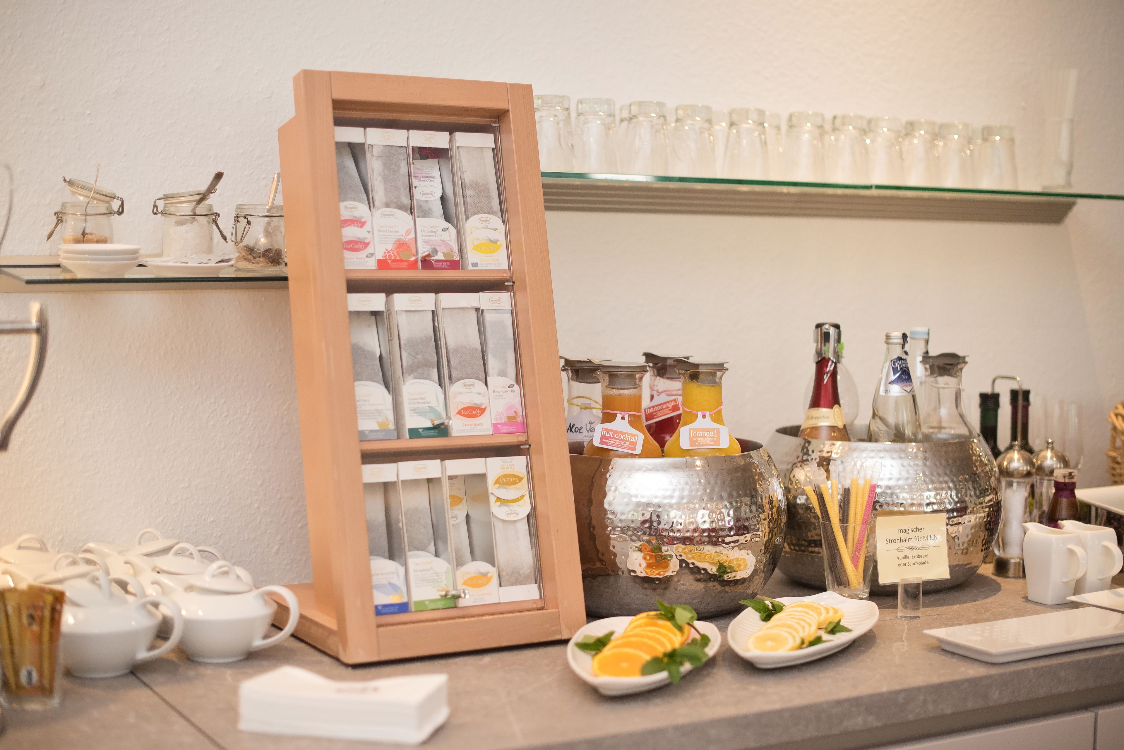 A breakfast bar with tea and coffee options, jars of spreads, and a variety of condiments.