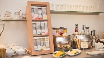 A breakfast bar with tea and coffee options, jars of spreads, and a variety of condiments.