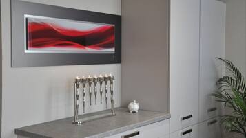 A modern interior with a grey cabinet, a white piggy bank, and a wall-mounted abstract art piece.