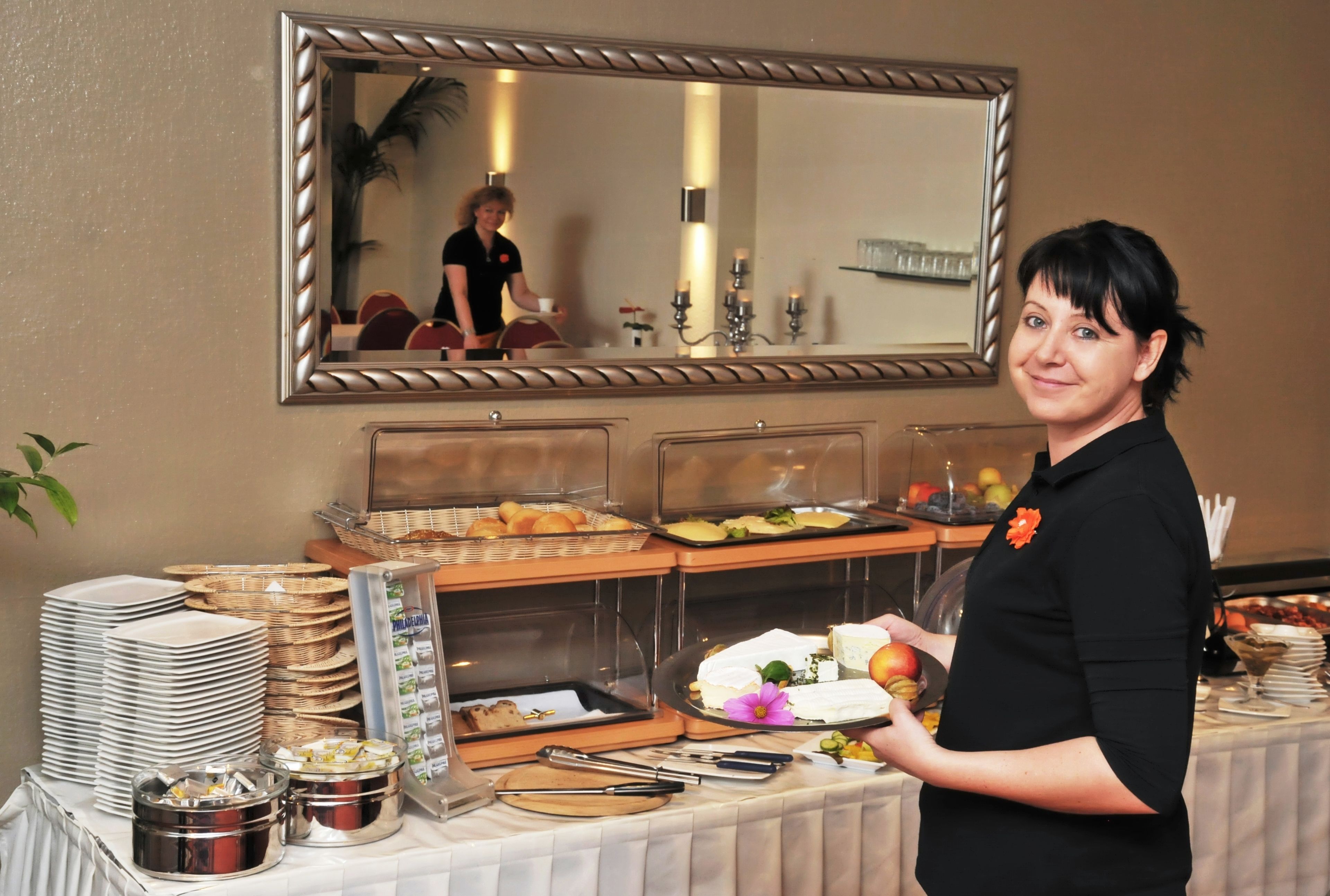 A buffet setup with various food items, plates, and utensils.