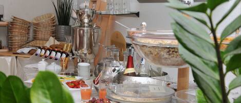 A buffet setup with various food items, glassware, and a coffee station.