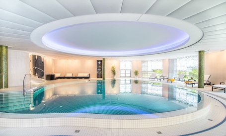 Indoor pool, pool loungers. Hotel VierJahreszeiten am Seilersee