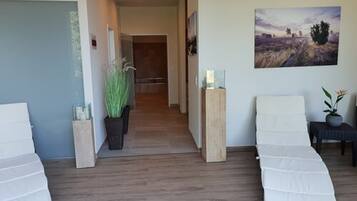 Relax in a serene space with a large abstract painting, two seating areas, and a tall plant.