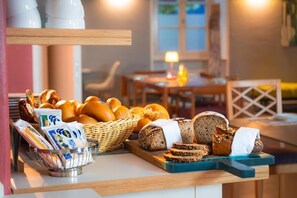 A breakfast buffet with various breads and pastries. - Hotel Bergbauer (Neuburg)