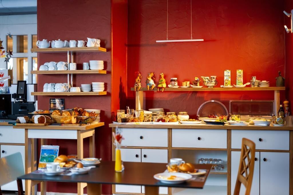 A breakfast buffet area with various food items and utensils.