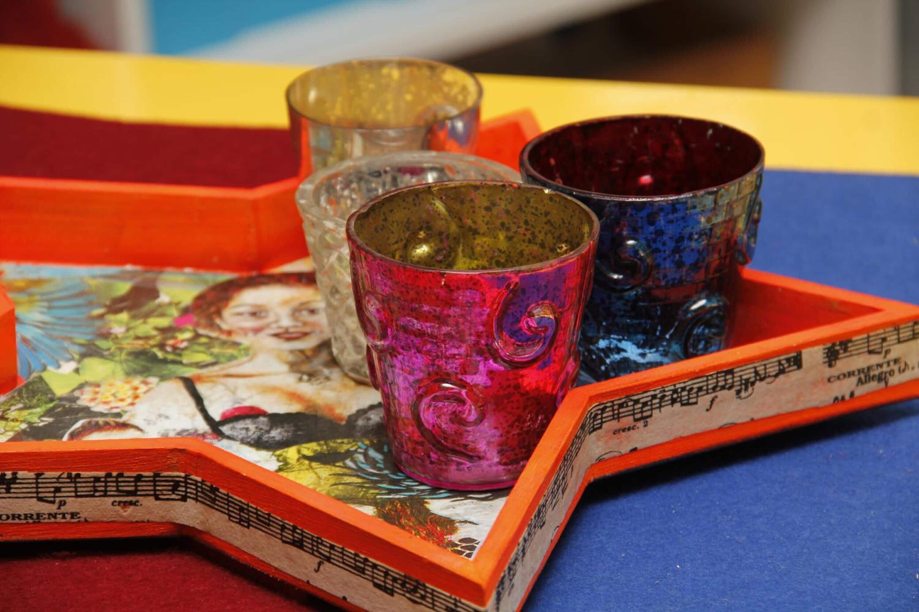 A tray with colorful glass cups and a book with a musical theme.