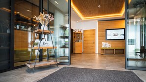 A reception area with a wooden reception desk, a glass wall, and a modern interior design. - Hotel-Gasthof Rose (Oberkirch)
