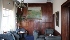 A room with a large painting, wooden paneling, a chandelier, and a view of the outdoors. - Hotel Stolteraa (Rostock)