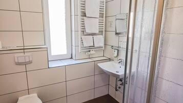 Een moderne badkamer met toilet, wastafel en douche.