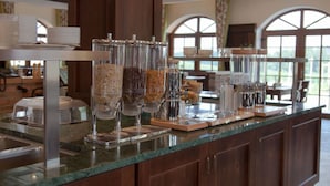 A buffet setup with various food dispensers and a counter. - Hotel Strasshof (Pfaffenhofen an der Ilm)