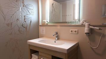 A bathroom with a sink, mirror, and towel rack.