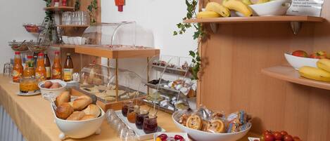 Um buffet de café da manhã com diversos alimentos e bebidas.