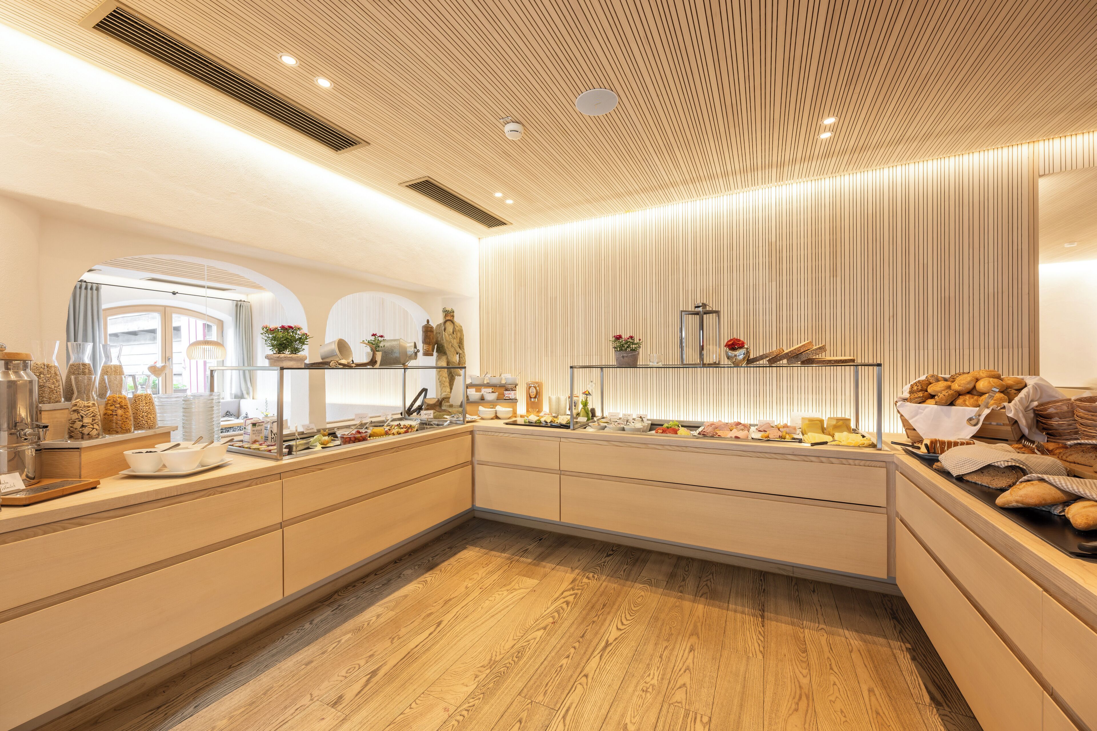 Une cuisine moderne avec un plancher en bois, des armoires intégrées et une variété d’aliments exposés sur le comptoir.