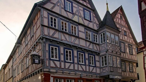 A traditional half-timbered building with multiple stories, a prominent gabled roof, and a sign for a hotel. - Hotel Schwanen (Mosbach)