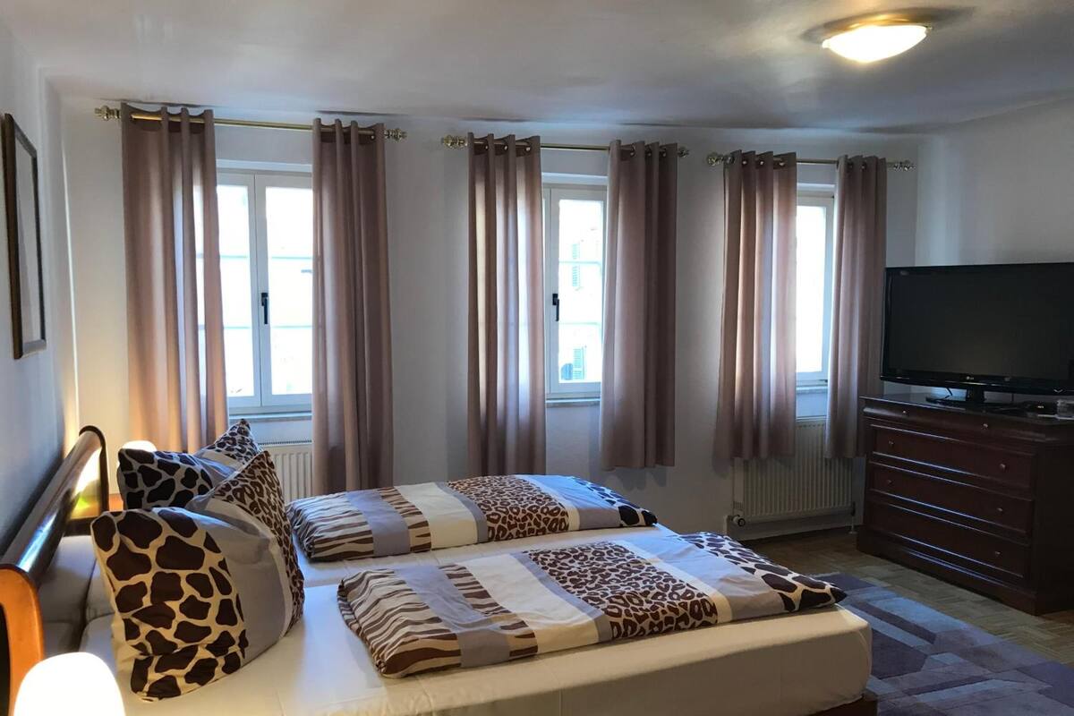 Un dormitorio con dos camas, un televisor y un aparador.