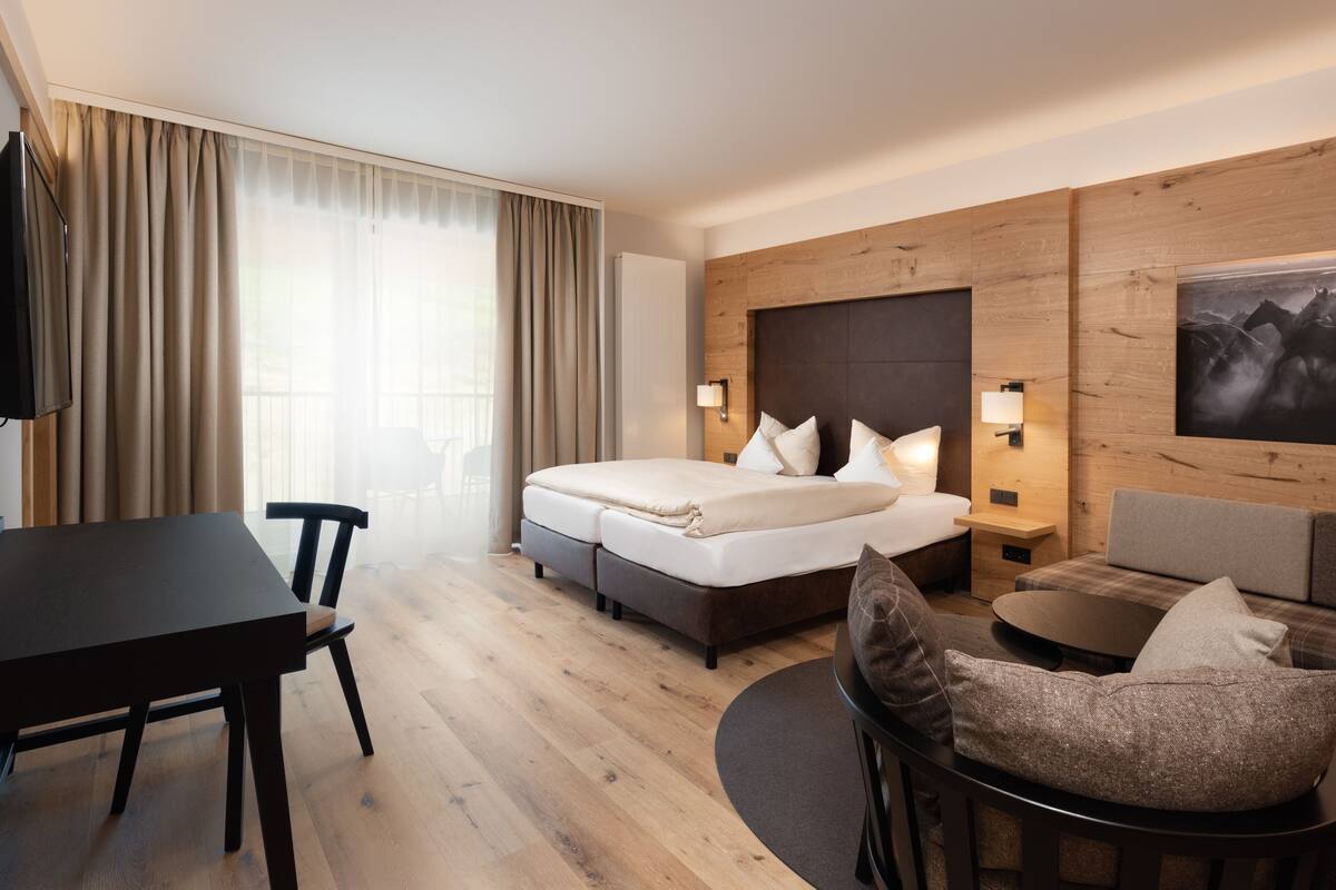 Une chambre d’hôtel moderne équipée d’un lit, d’un bureau, d’un canapé et d’une télévision.