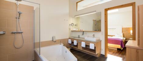 A modern bathroom with a bathtub, shower, and vanity.