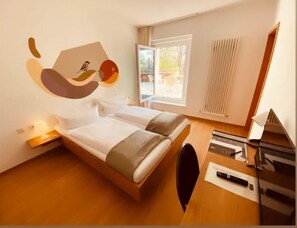 Une pièce comprenant un lit, un bureau, une chaise, une fenêtre et un élément de décoration murale.