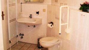 A small bathroom with a toilet, sink, and mirror. - Landhotel Peters (Wustrow)