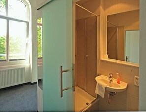 A bathroom with a bathtub, a sink, and a large mirror. - Hotel zwischen den Seen (Waren (Müritz))