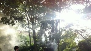 Un patio al aire libre con suelo de piedra, una parrilla y sillas.