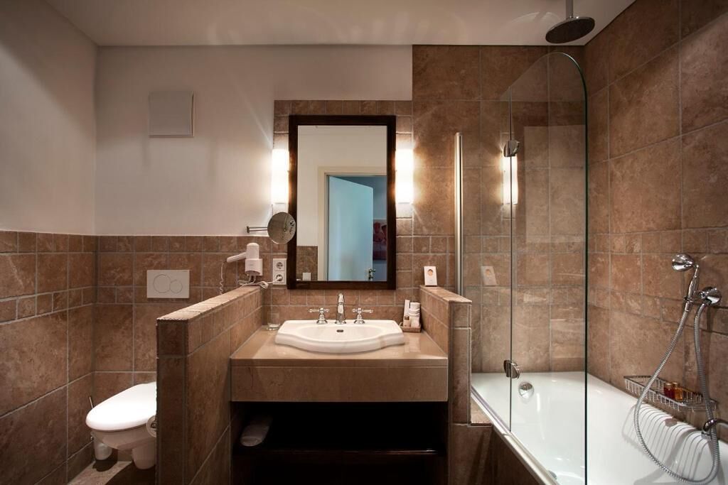 Une salle de bain moderne avec une douche à parois de verre, un lavabo blanc et des toilettes.