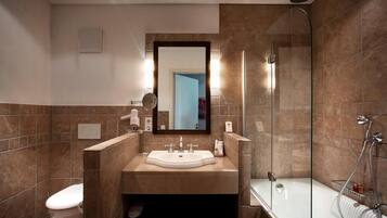 Une salle de bain moderne avec une douche à parois de verre, un lavabo blanc et des toilettes.