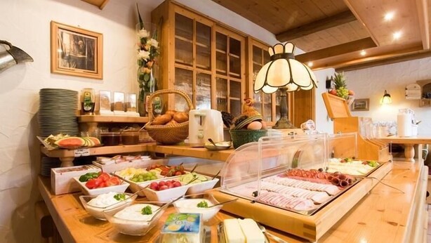 A buffet with various food items and a wooden interior. - Pension Sommer (Waldsassen)