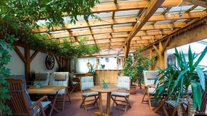 An outdoor patio with wooden furniture and a pergola structure. - Pension Sommer (Waldsassen)