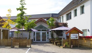 A courtyard with outdoor seating, a wooden fence, and a building with a sign that reads "Hof". - Gasthaus Bonneberger Hof (Vlotho)