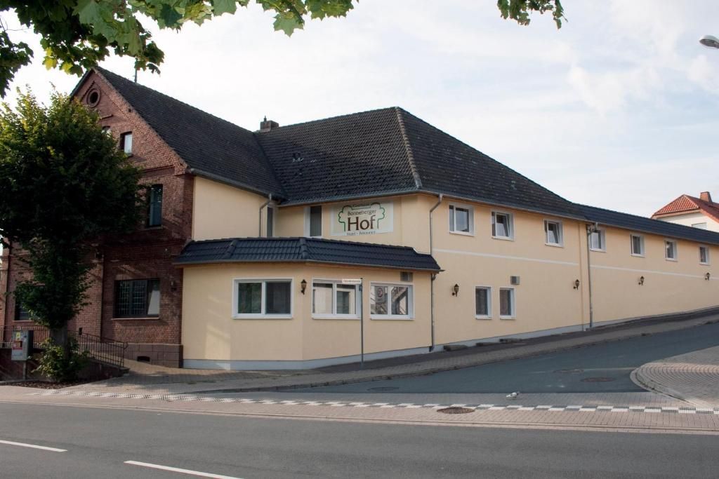 Um edifício de dois andares com uma placa que diz 'Hotel Hof'.