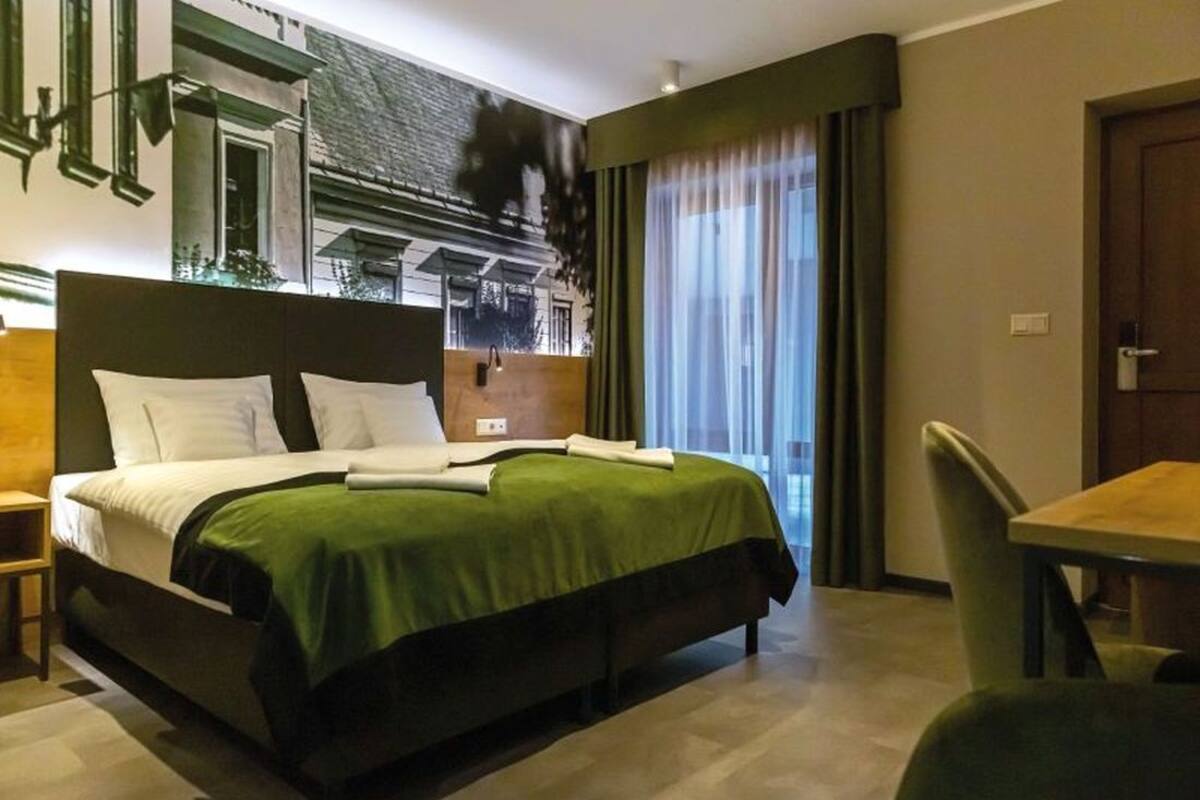 A hotel room with a bed, a desk, and a chair.