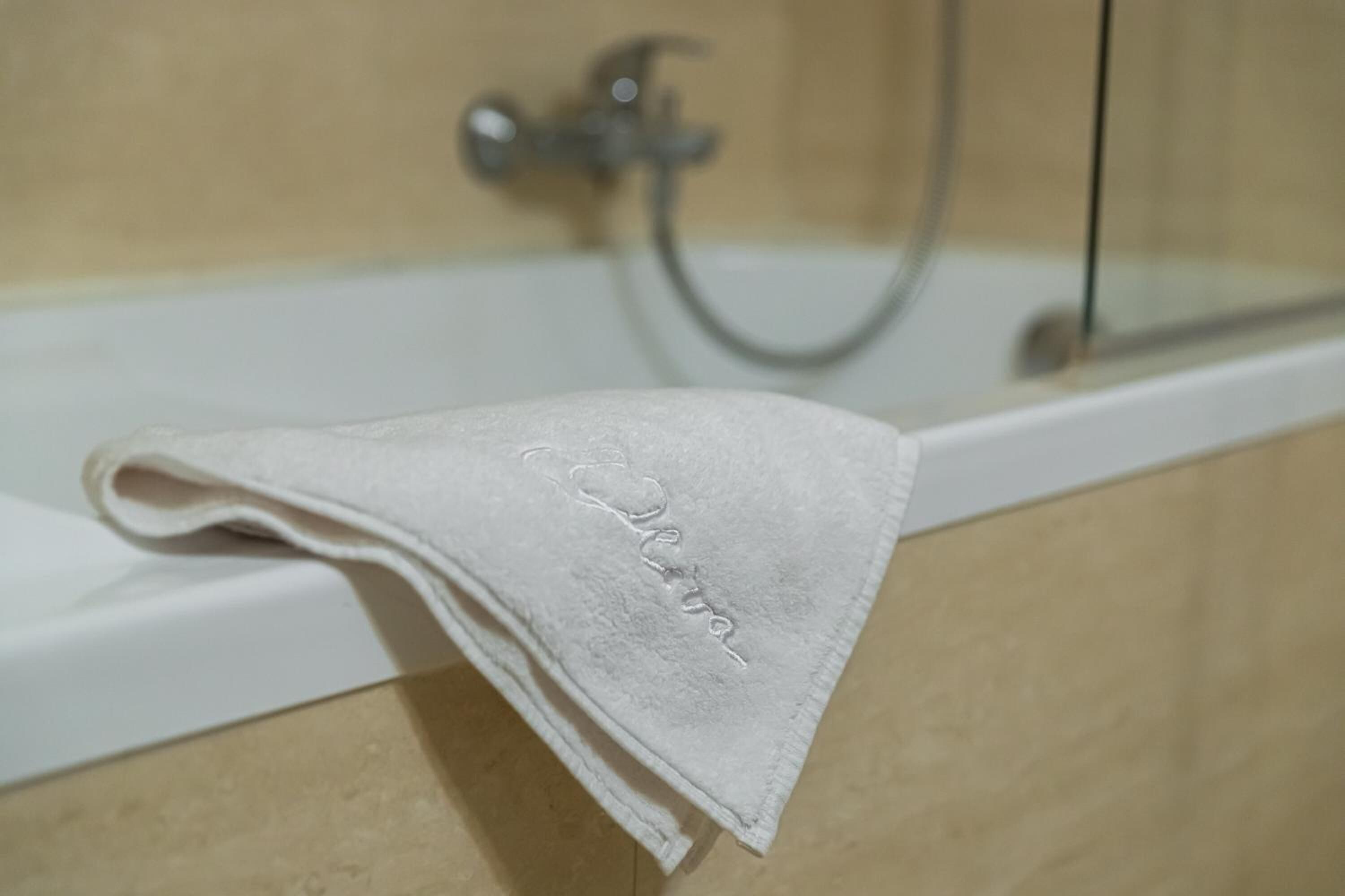 Een witte handdoek met opdruk in een badkuip in een badkamer.
