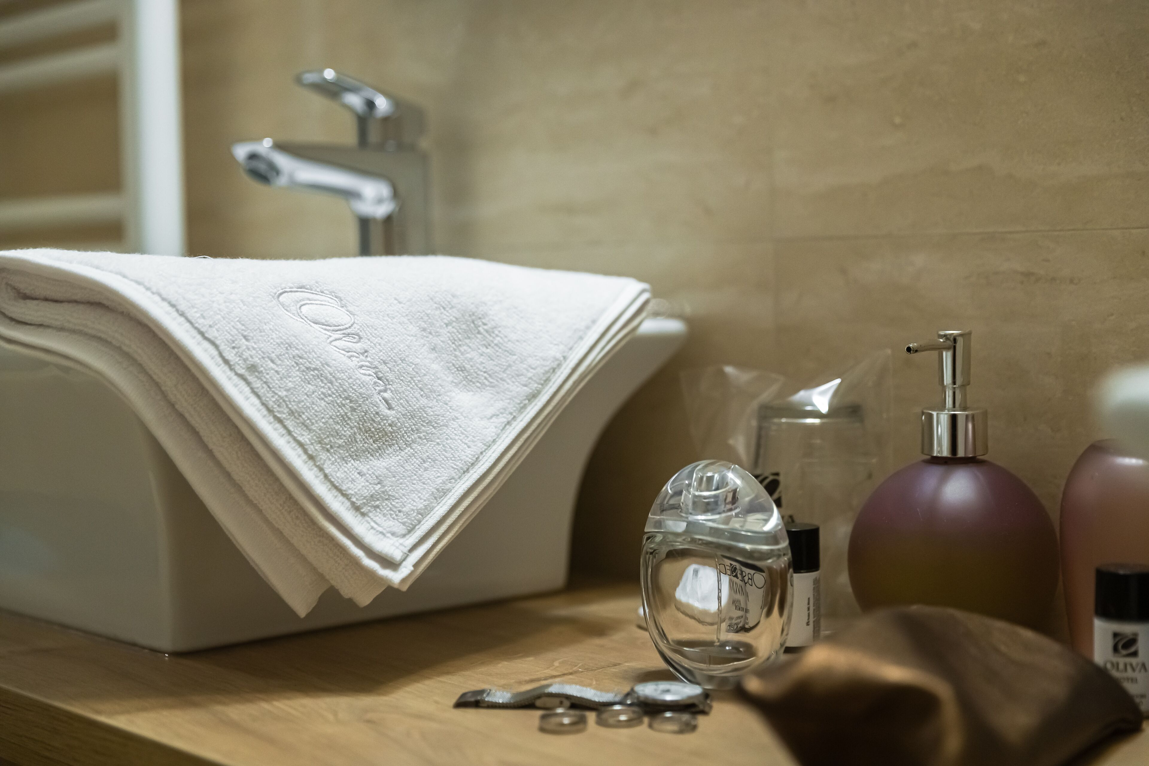 A bathroom with a sink, towel, and toiletries.