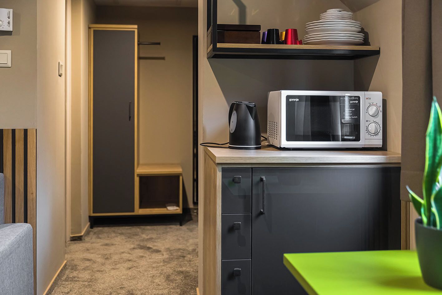 A compact kitchen with a microwave, a coffee maker, and a small cabinet.