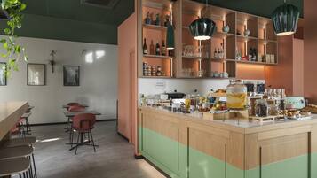 Una cocina moderna con una isla central, estantes de madera y lámparas colgantes.